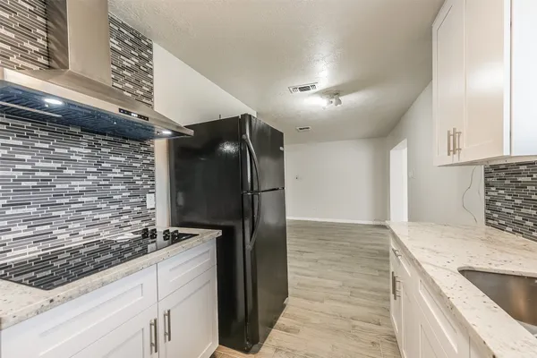 a kitchen with stainless steel appliances granite countertop a refrigerator and a sink