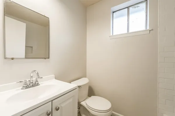 a bathroom with a toilet a sink a vanity and mirror