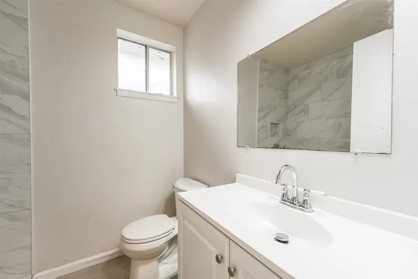 a bathroom with a sink toilet and mirror