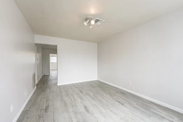 a view of an empty room with wooden floor