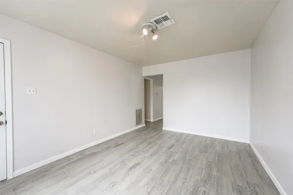 a view of an empty room with wooden floor
