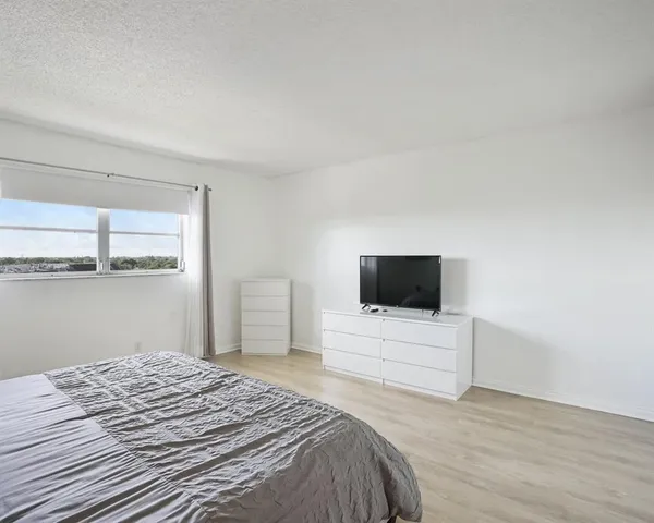 a bedroom with a bed and flat screen tv