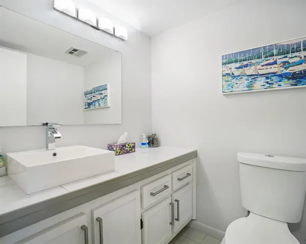 a bathroom with a sink mirror and toilet