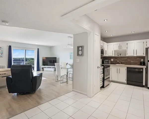 a kitchen with granite countertop a refrigerator and cabinets