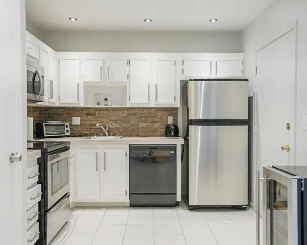 a kitchen with stainless steel appliances granite countertop a refrigerator and a stove
