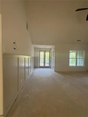 a view of a big room with windows and chandelier fan