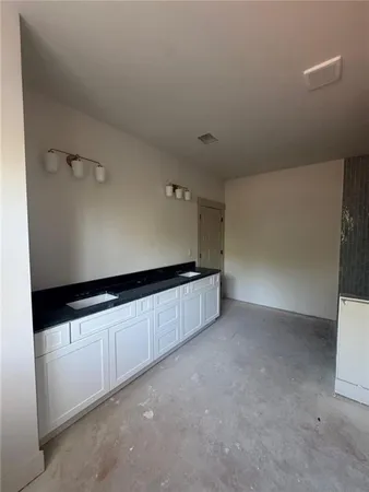 a kitchen with granite countertop white cabinets and white appliances