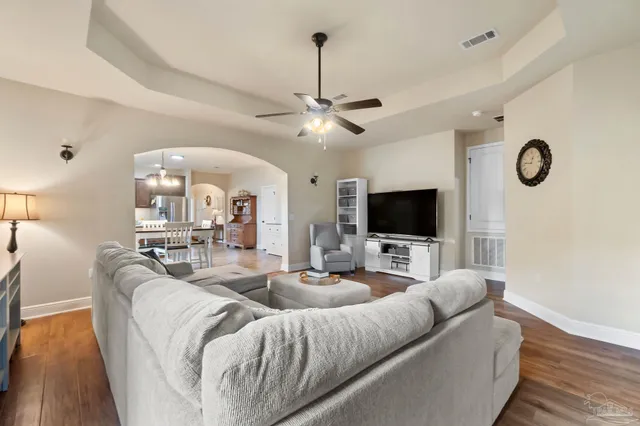 a living room with furniture a flat screen tv and a wall painting