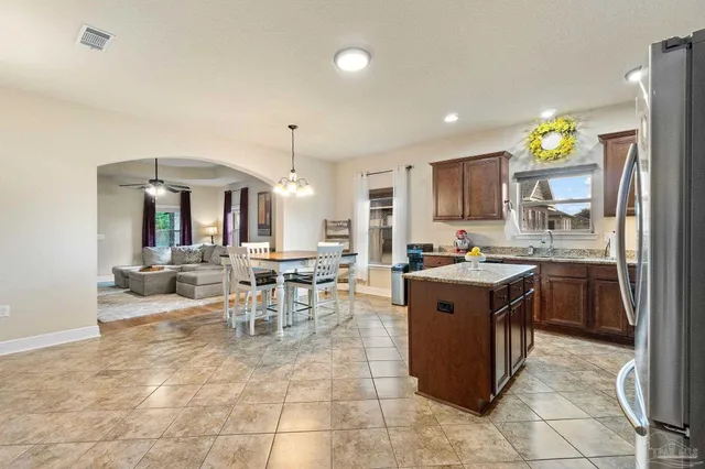 a large kitchen with a counter space a sink stainless steel appliances and cabinets