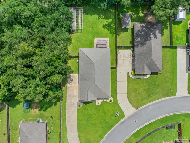 a front view of a house with a yard and potted plants