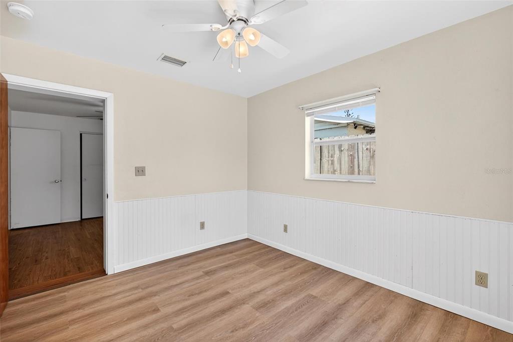 47 Carol Road Ormond Beach, FL 32176 - Photo 18 of 54 an empty room with wooden floor chandelier fan and windows