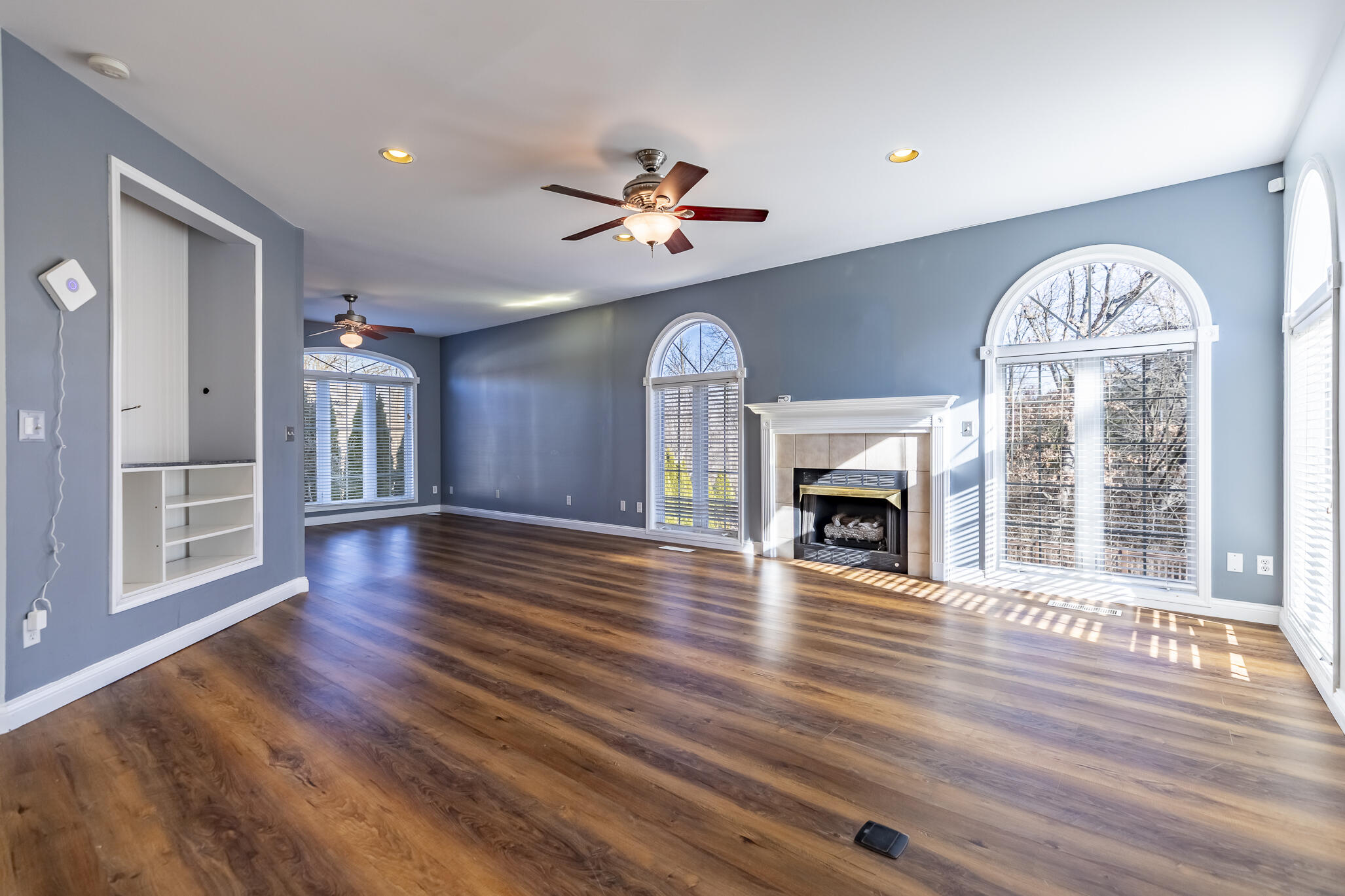 8049 West 85th Court Crown Point, IN 46307 - Photo 25 of 47 a view of a livingroom with wooden floor a fireplace and window