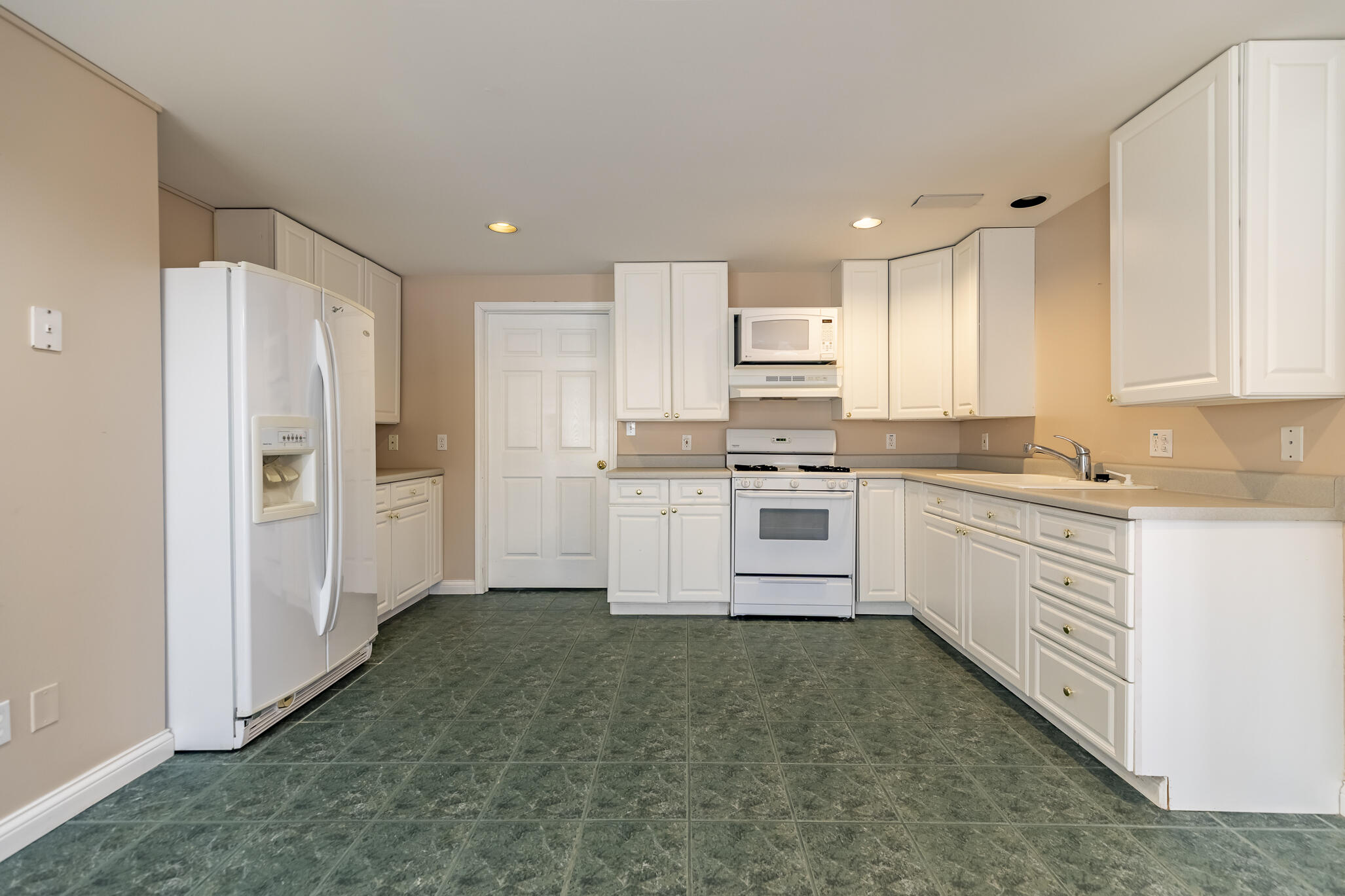 8049 West 85th Court Crown Point, IN 46307 - Photo 37 of 47 a kitchen with white cabinets and white appliances