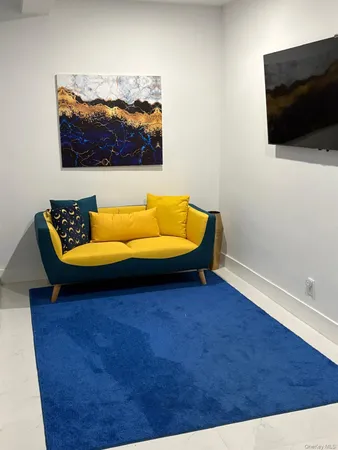 a blue couch sitting in a living room next to a flat screen tv