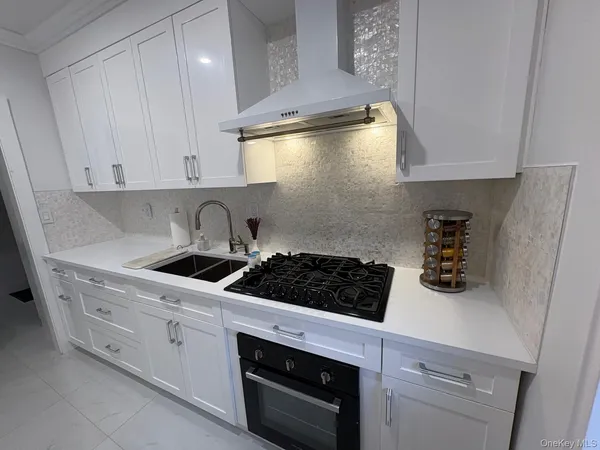 a kitchen with a stove and white cabinets