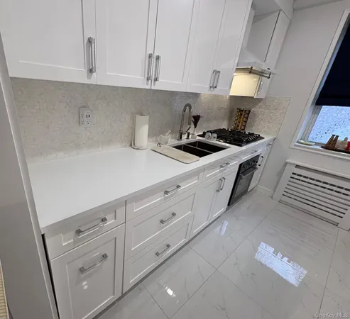 a kitchen with white cabinets and white appliances