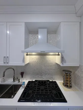 a kitchen with a sink a stove and cabinets