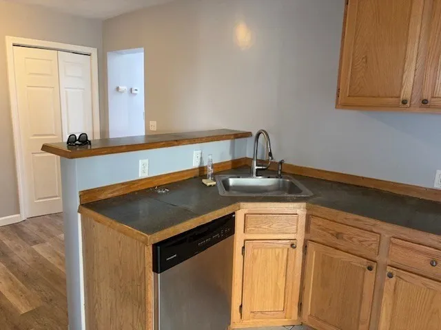 a kitchen with a sink cabinets and a wooden floor