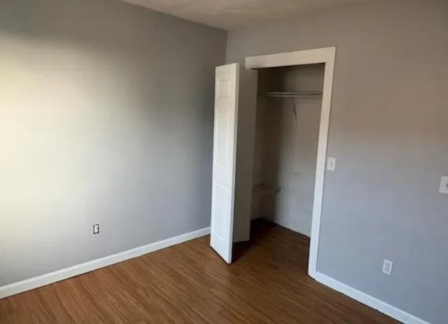 an empty room with wooden floor and closet