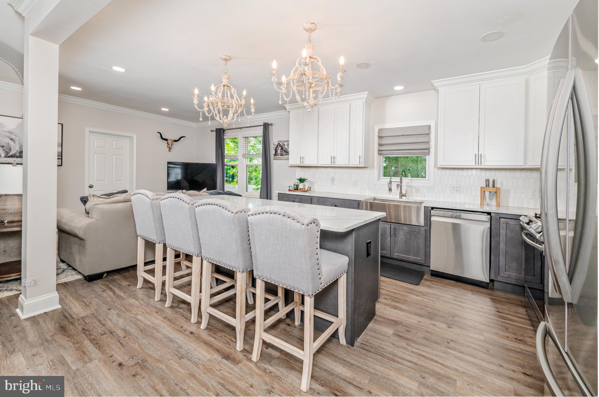 16 Townsend Avenue Berlin, NJ 08009 - Photo 11 of 50 a kitchen with stainless steel appliances a dining table chairs a sink and dishwasher a refrigerator with wooden floor