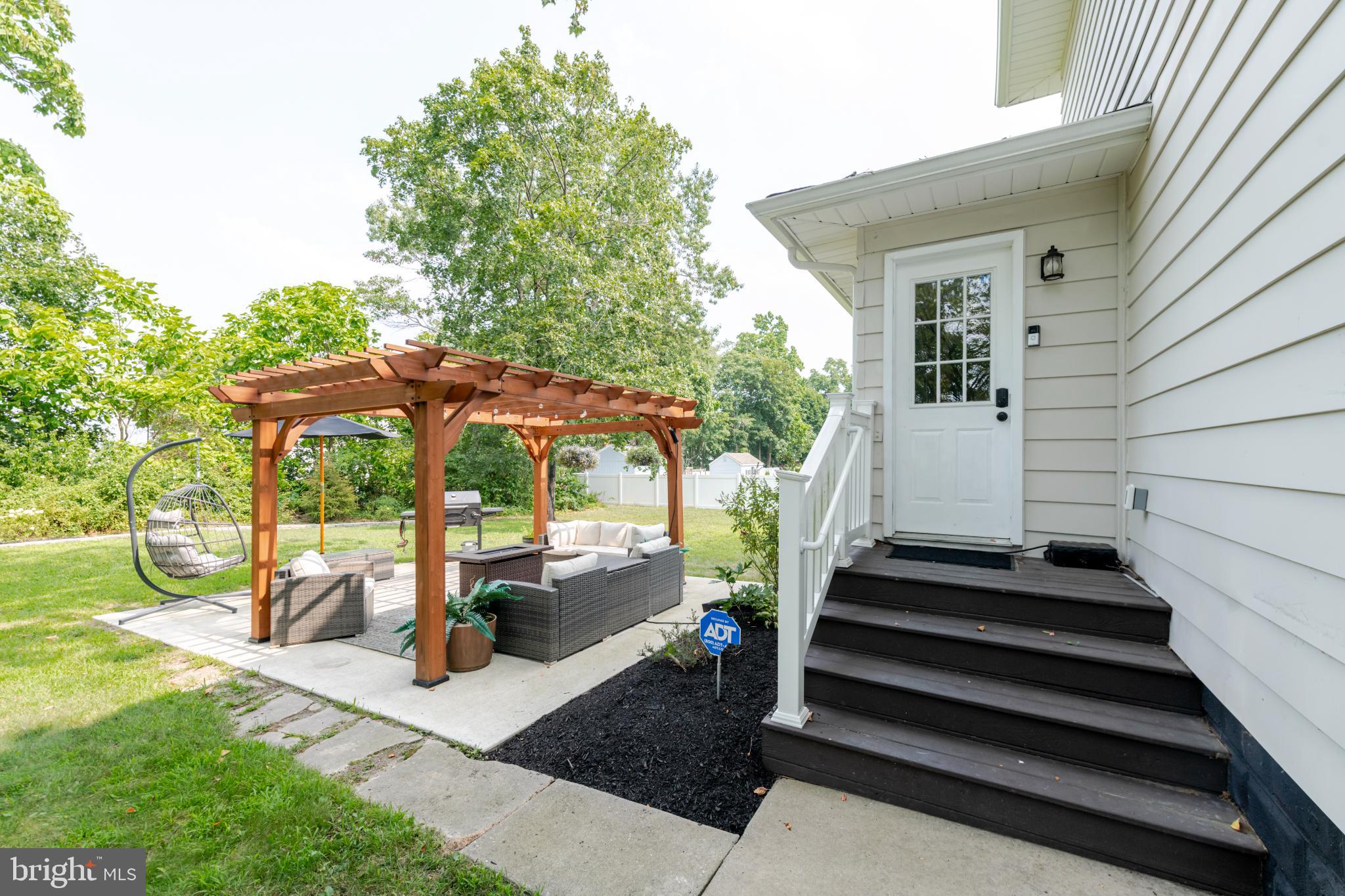 16 Townsend Avenue Berlin, NJ 08009 - Photo 36 of 50 a view of a patio with table and chairs under an umbrella with a small yard