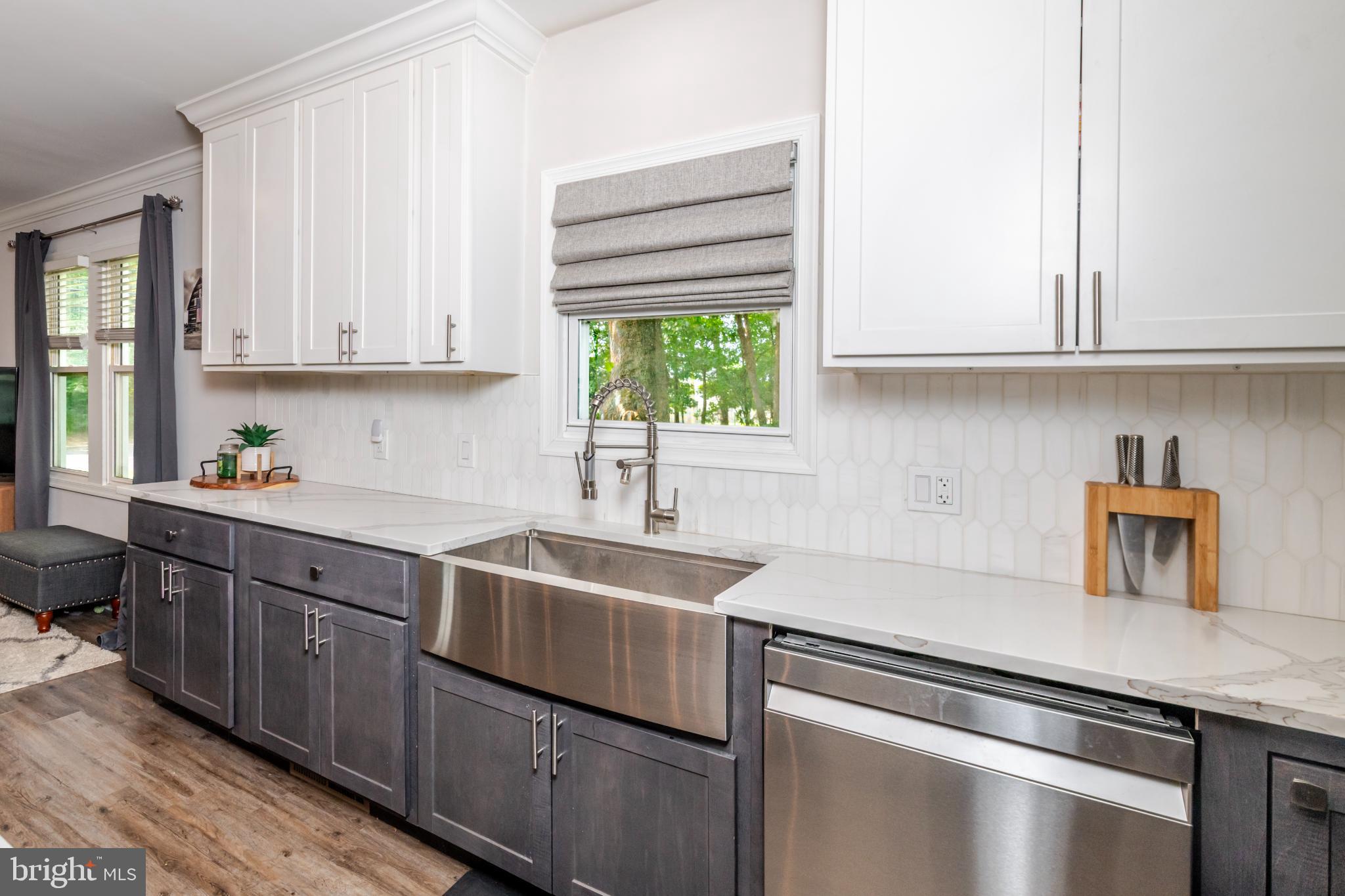 16 Townsend Avenue Berlin, NJ 08009 - Photo 7 of 50 a kitchen with stainless steel appliances granite countertop a sink dishwasher stove and white cabinets with wooden floor
