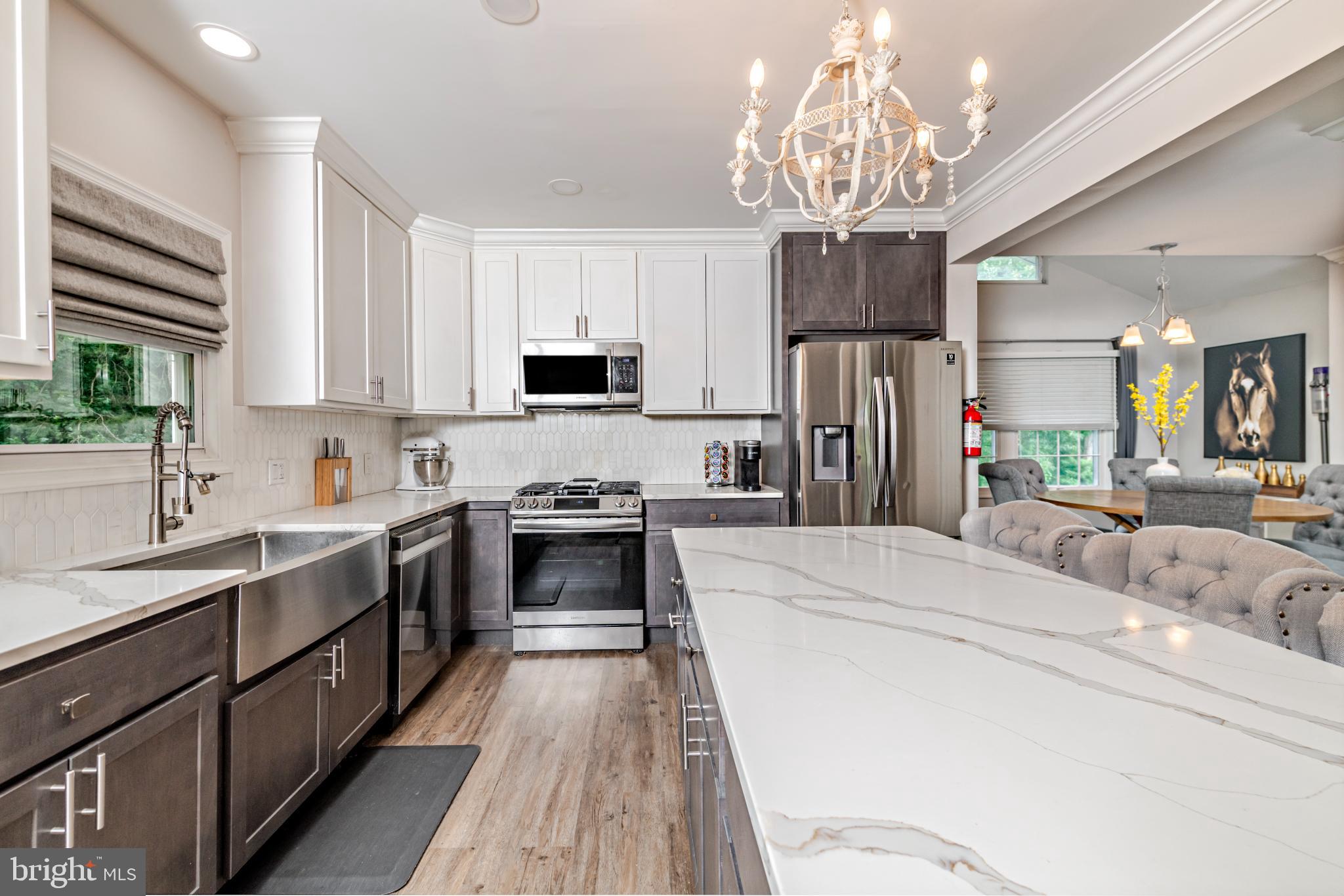 16 Townsend Avenue Berlin, NJ 08009 - Photo 8 of 50 a kitchen with kitchen island granite countertop a sink dishwasher a stove a refrigerator and a dining table with wooden floor