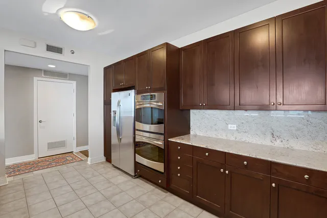 a kitchen with stainless steel appliances granite countertop a refrigerator and a sink
