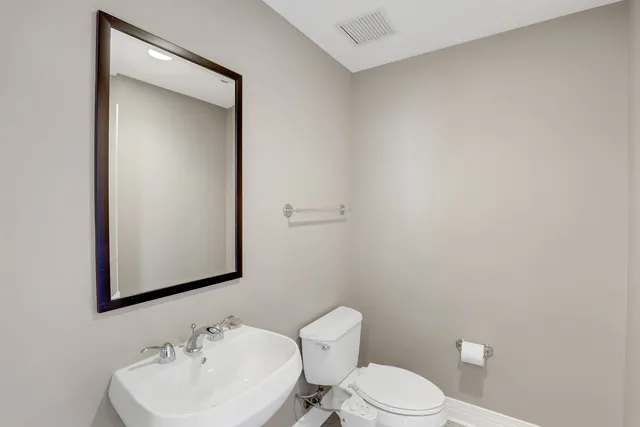 a bathroom with a toilet a sink and mirror
