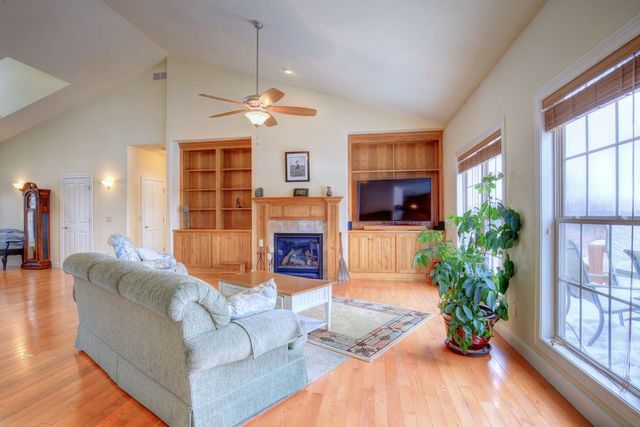 8038 Adam Road Weldon, IL 61882 - Photo 14 of 53 a living room with furniture a fireplace and a flat screen tv