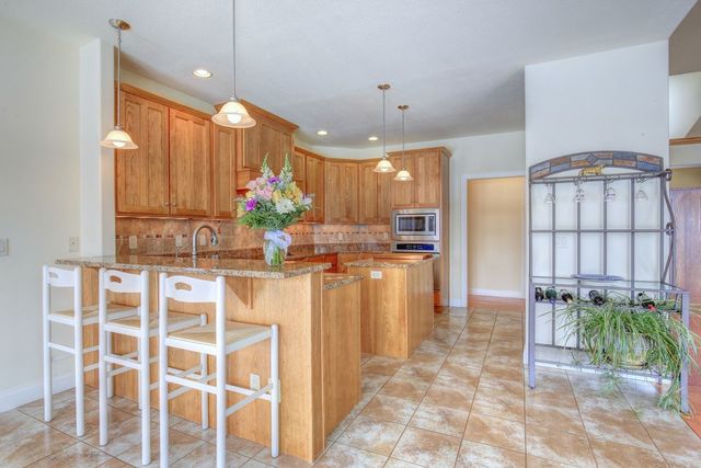 8038 Adam Road Weldon, IL 61882 - Photo 16 of 53 a kitchen with stainless steel appliances kitchen island granite countertop a refrigerator and microwave