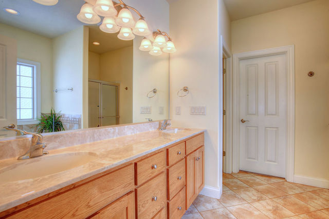 8038 Adam Road Weldon, IL 61882 - Photo 27 of 53 a spacious bathroom with a granite countertop sink a mirror and a shower
