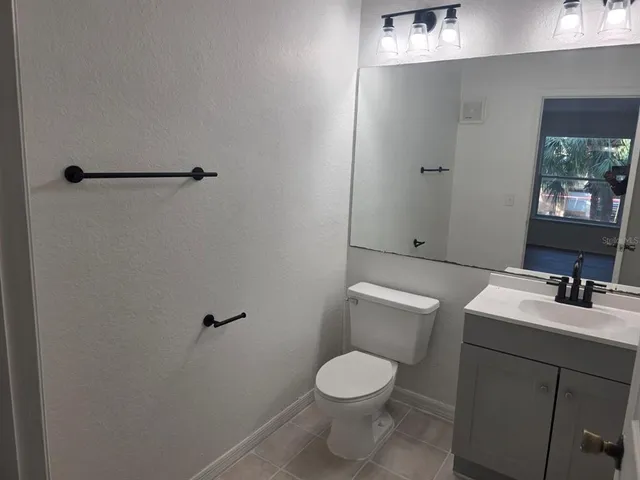 a bathroom with a toilet sink vanity and mirror
