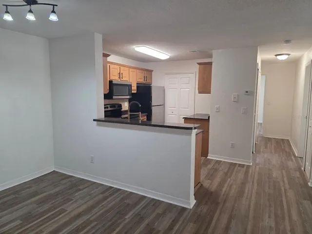 a view of a kitchen with wooden floor and electronic appliances