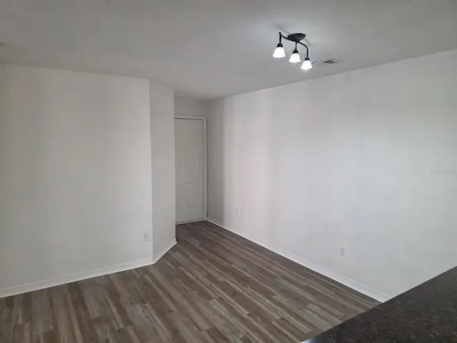 a view of room with wooden floor and fan