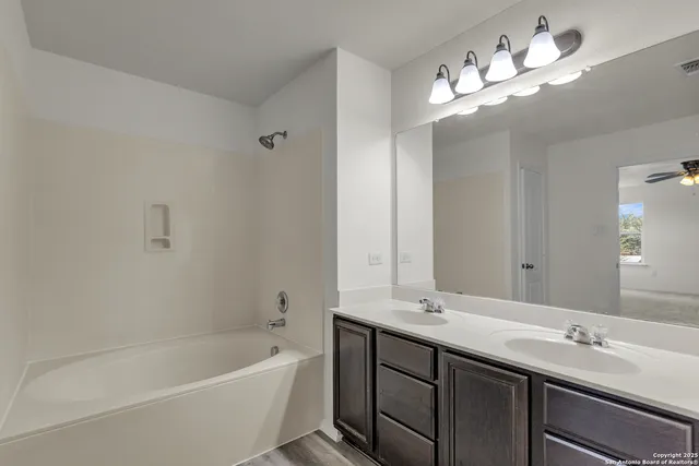 a spacious bathroom with a double vanity sink toilet and a mirror
