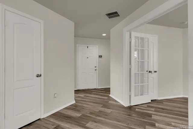 a view of a hallway with wooden floor