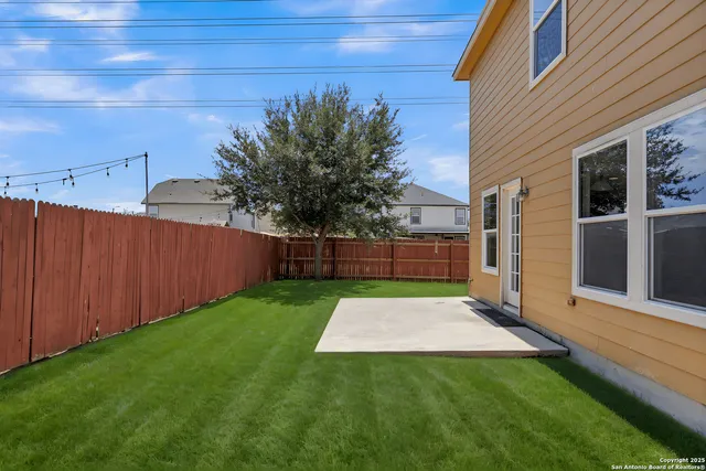 a backyard of a house with table and chairs
