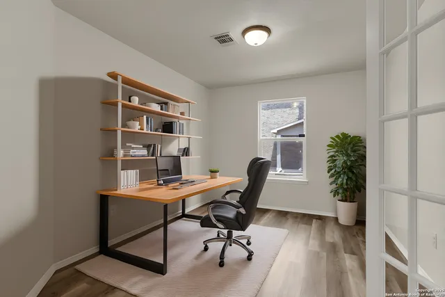 a view of a workspace with furniture and a potted plant