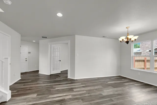 a view of empty room with wooden floor and window