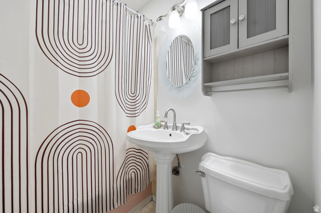 1486 3rd Street Ogden, UT 84404 - Photo 9 of 26 Pedestal sink with chrome faucet, wall-mounted storage cabinet, and white toilet