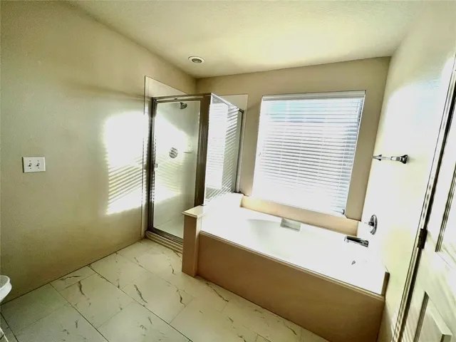 a spacious bathroom with a tub sink and shower