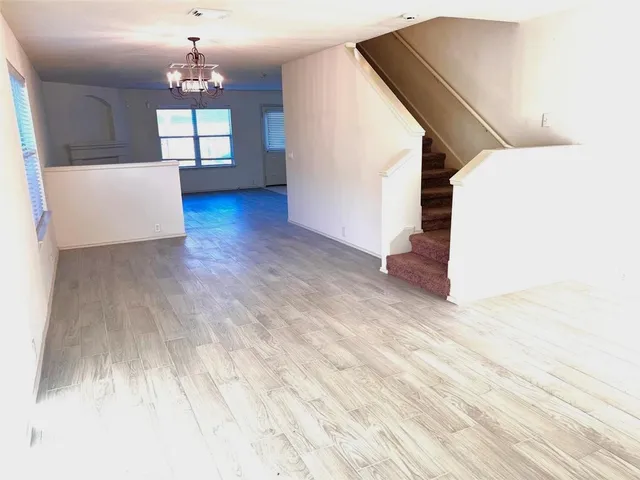 a view of a livingroom with wooden floor and stairs