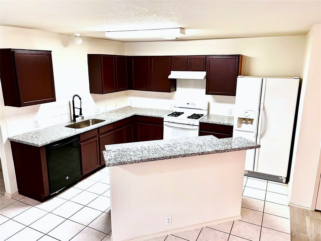 10219 Sugarbridge Trail Sugar Land, TX 77498 - Photo 5 of 16 a kitchen with granite countertop cabinets and refrigerator
