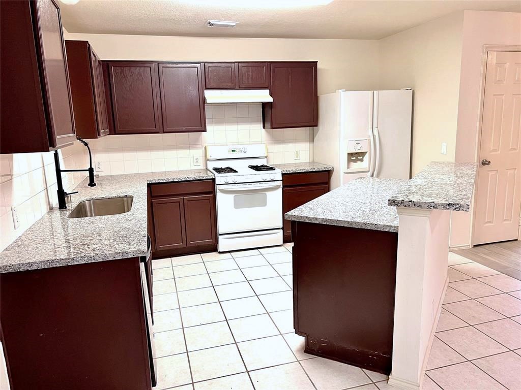 10219 Sugarbridge Trail Sugar Land, TX 77498 - Photo 6 of 16 a kitchen with stainless steel appliances granite countertop a sink stove and refrigerator