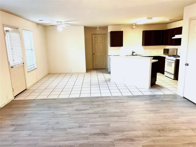 a view of a living room with a flat screen tv and kitchen view