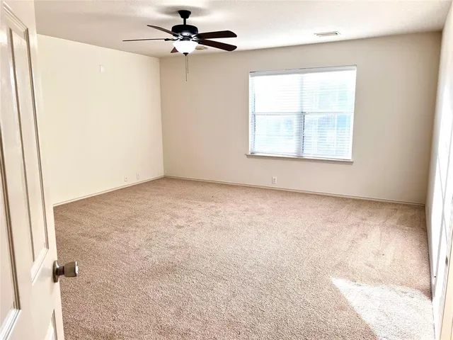an empty room with windows and fan