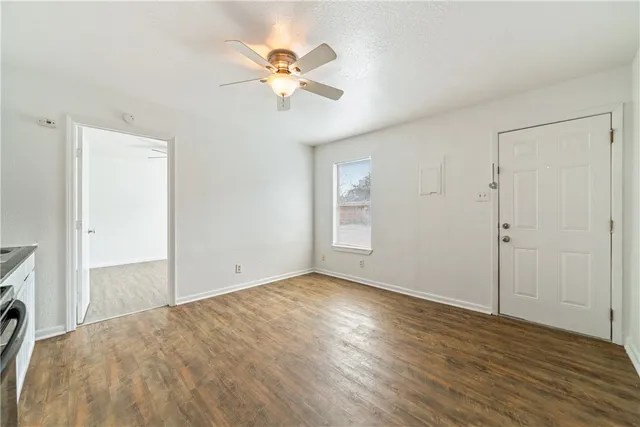 a view of empty room with wooden floor