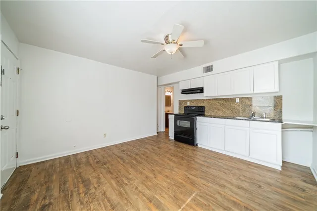 a kitchen with a refrigerator and white cabinets