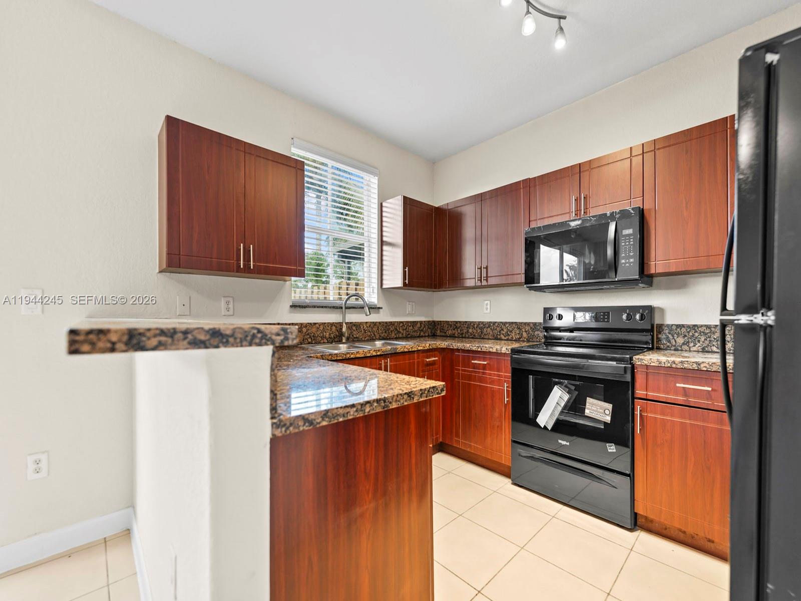 2441 Southeast 14 Street Homestead, FL 33035 - Photo 14 of 32 a kitchen with stainless steel appliances granite countertop a stove top oven a sink and dishwasher